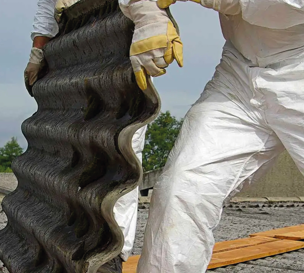 Photo of a worker lifting roofing