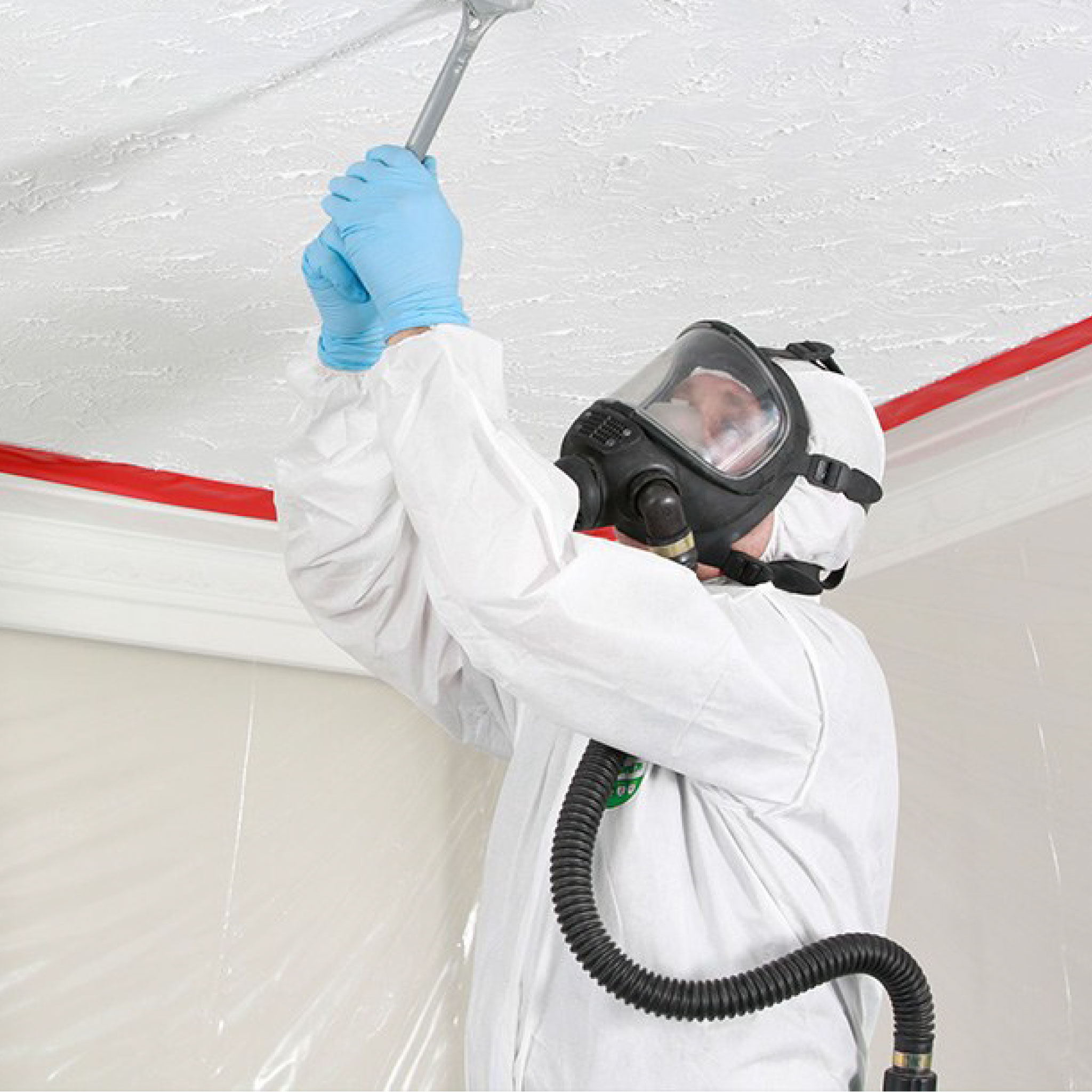 Photo of a worker in full protective gear working on a ceiling