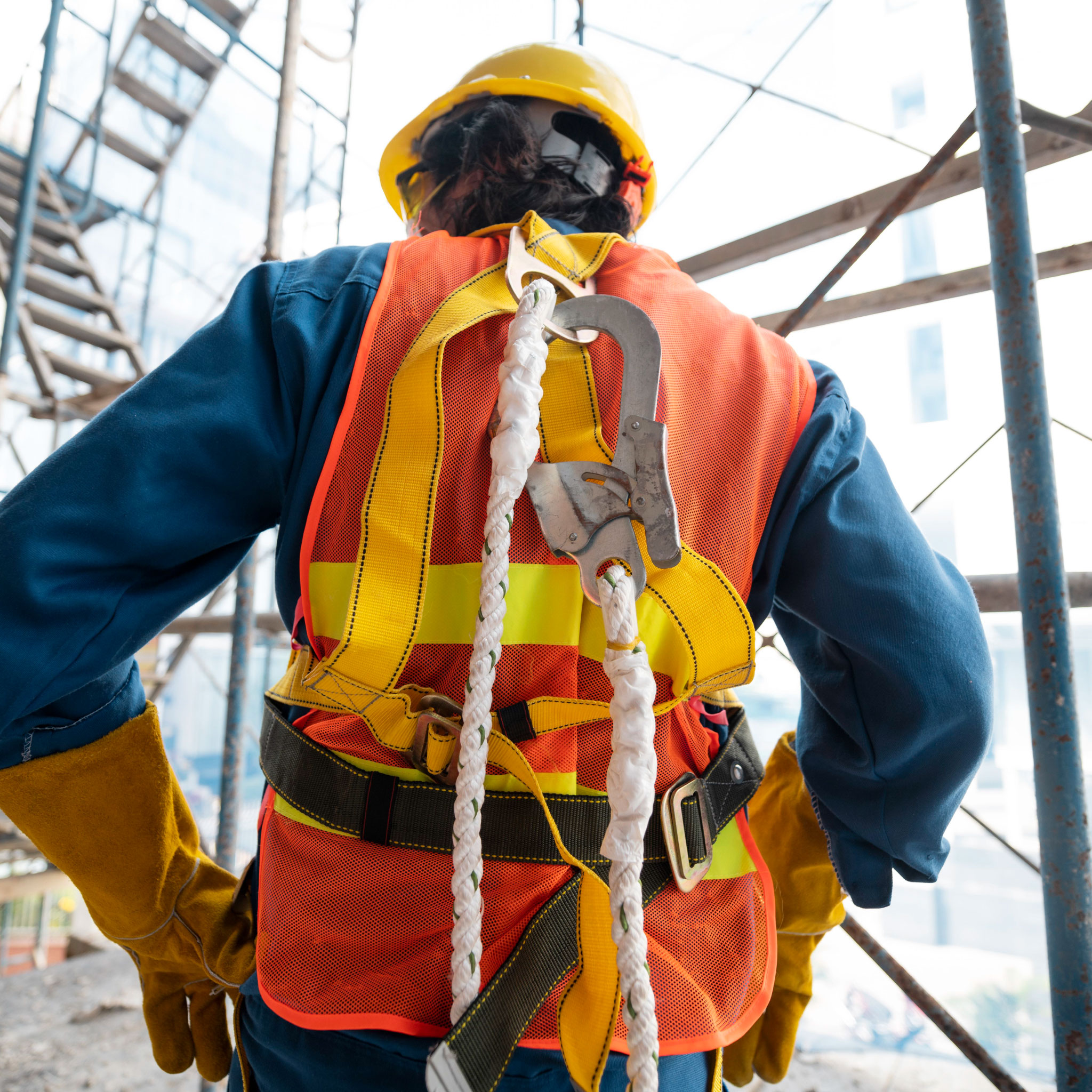 Image of a construction wearing a hard hat and protective gear who has been clipped and harnessed for working at height.