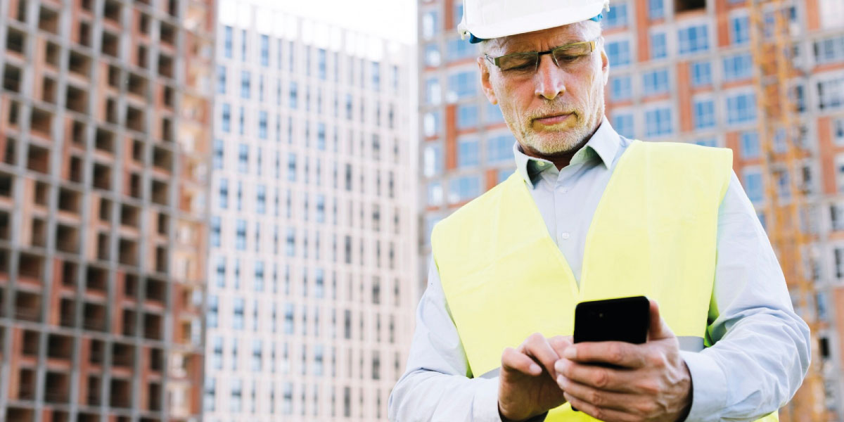 Photo of a construction supervisor looking at a phone