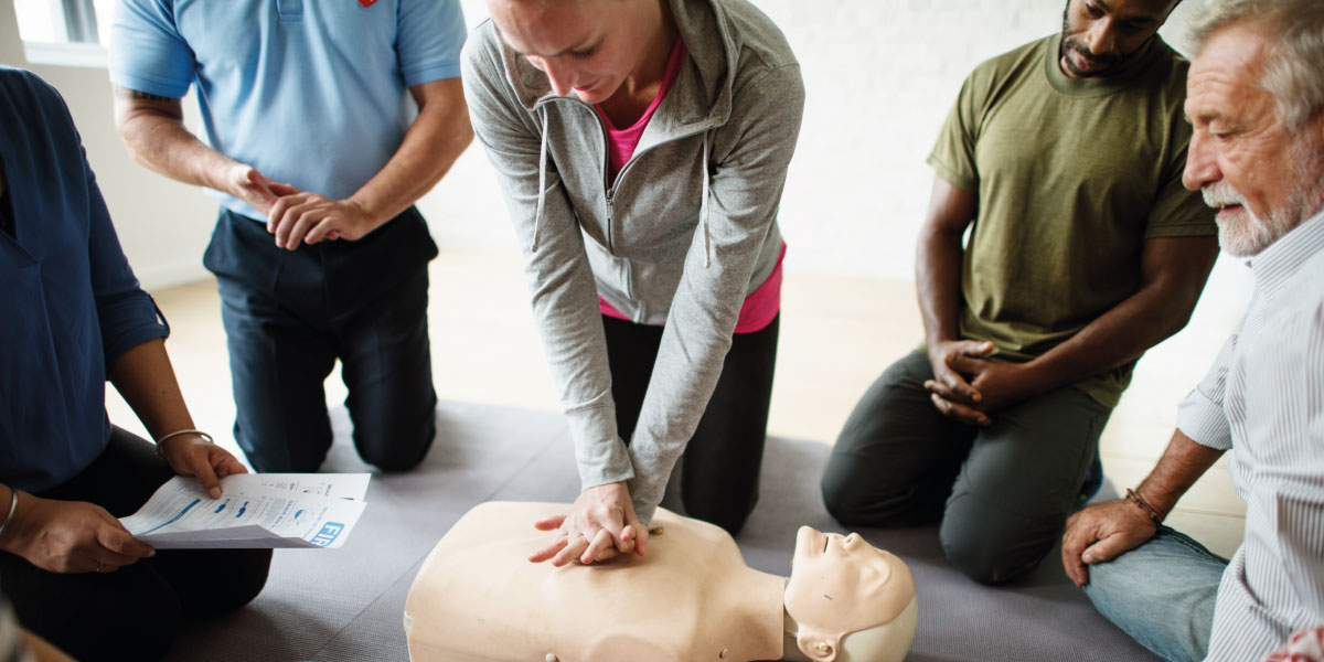 Photo of workers learning CPR on a CPR dummy