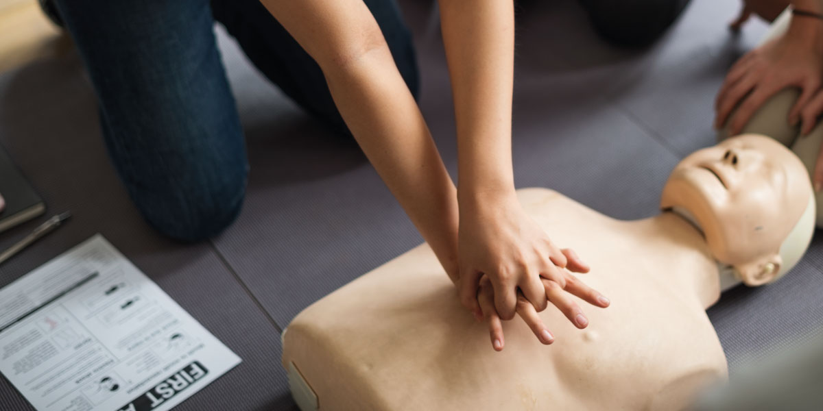 Photo of workers learning CPR on a CPR dummy