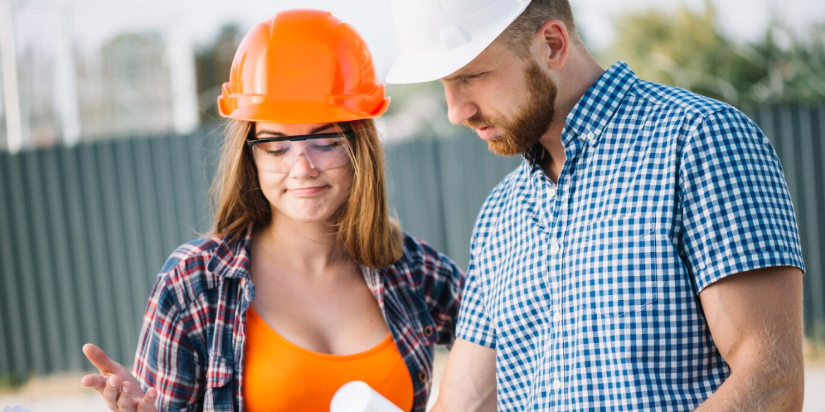 Photo of two construection workers looking at plans