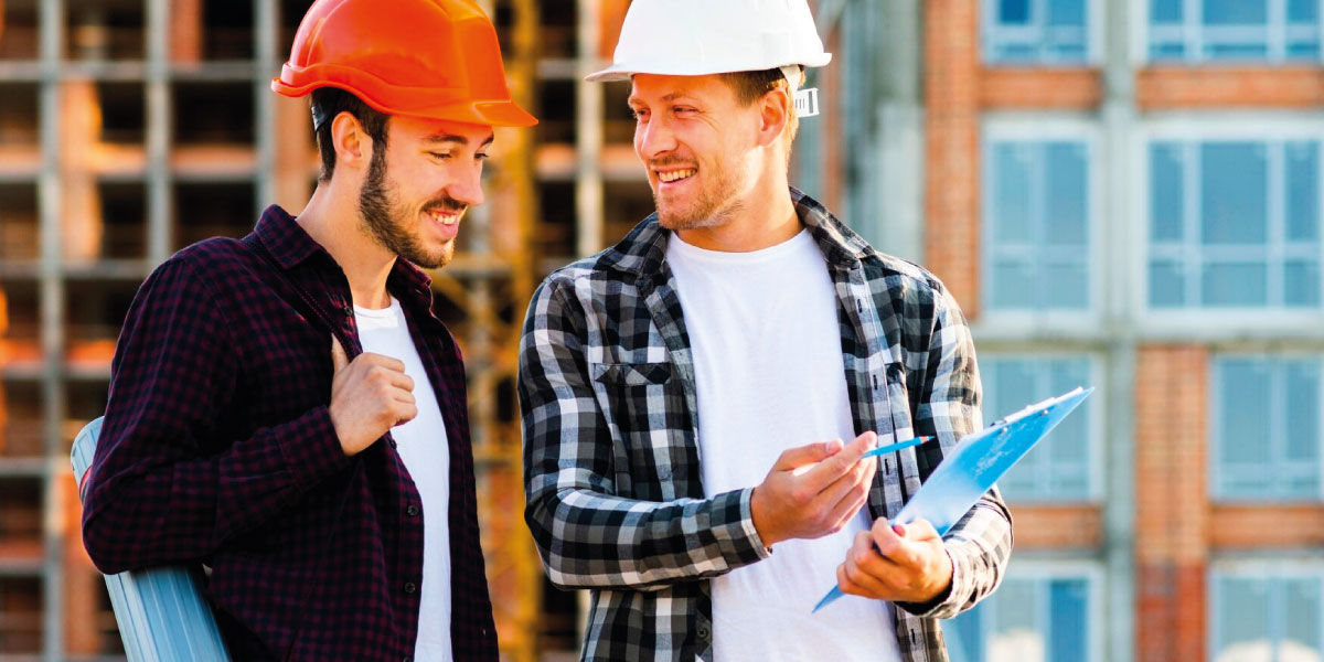 Photo of two construction workers looking at a clipboard