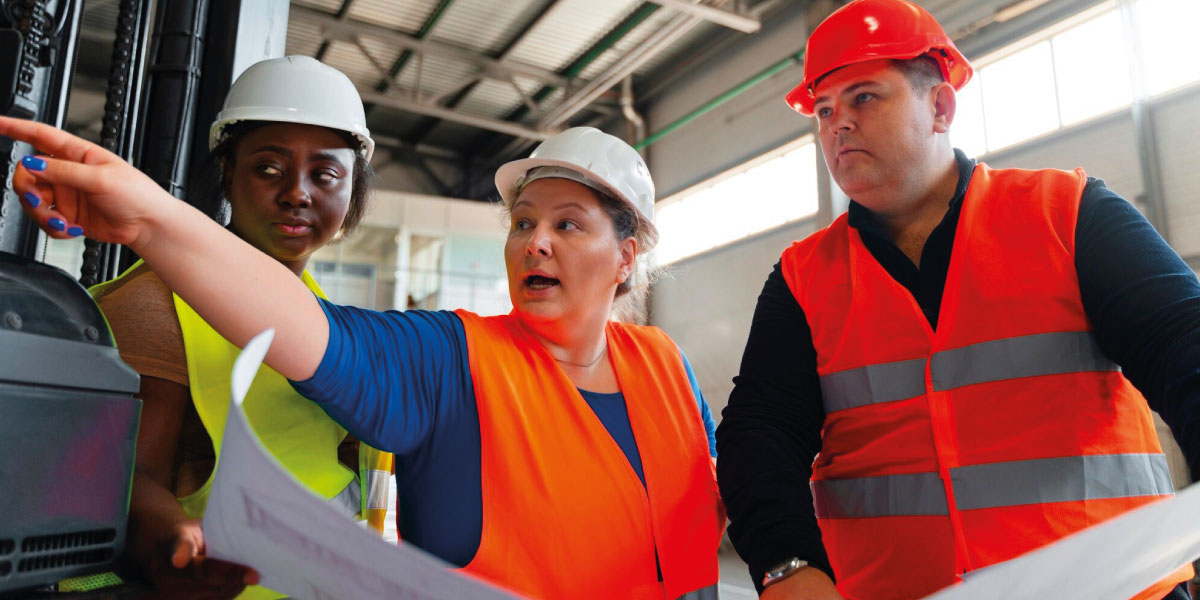 Photo of 3 construction workers hacing a discussion