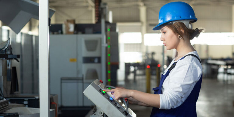 Photo of a worker wearing PPE using a machine