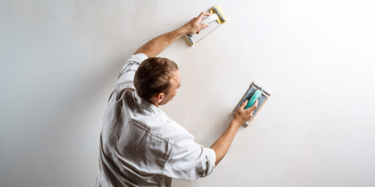 Photo of a worker plastering a wall