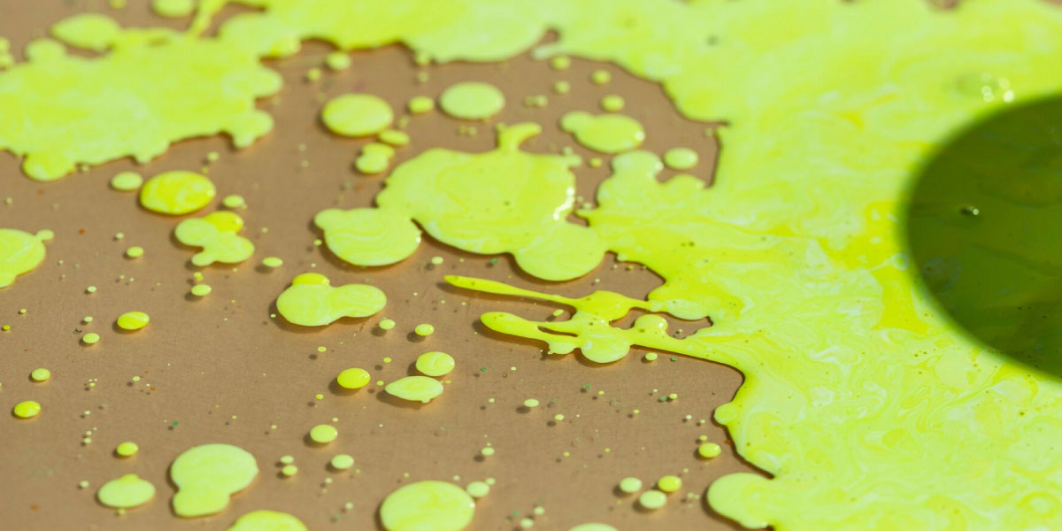 Photo of a bright yellow liquid which has been spilled on the floor