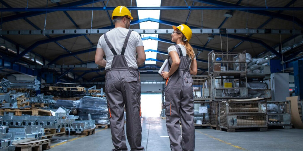 Photo of two factory workers wearing PPE