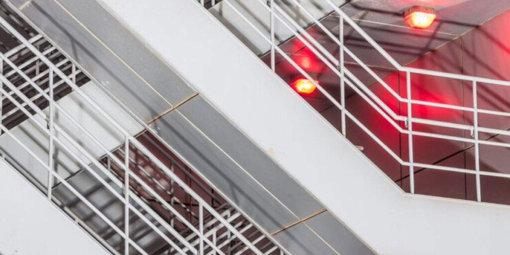 Photo of stairs which are lit up by red emergency lights