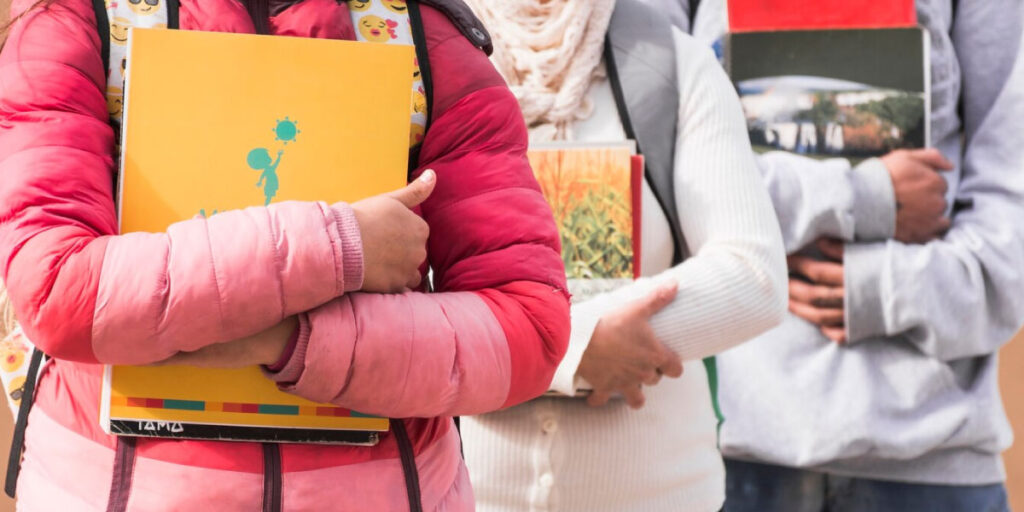 Photo of students holding their books