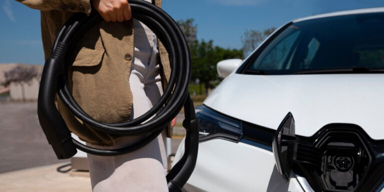 Photo of a man holding an electric vehicle charging cable