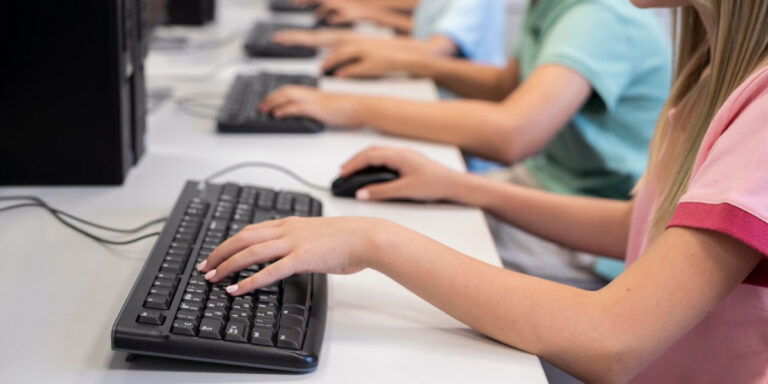 Photo of students typing on a computer