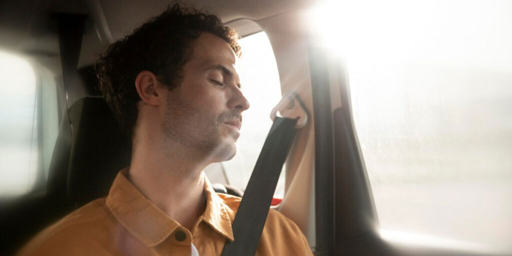 Photo of a man in the car with his eyes closed