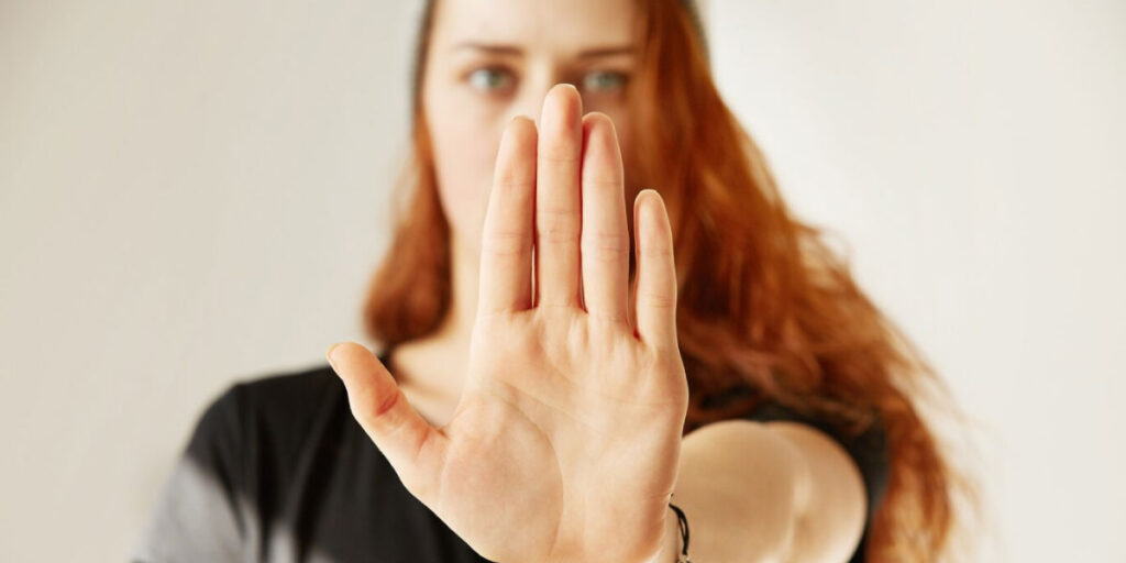 Photo of a woman holding up her hand in a 'stop' motion