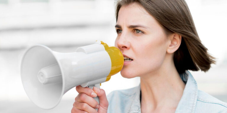 Photo of a woman speaking into a megaphone