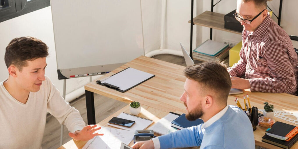 Photo of 3 workers having a discussion in the office