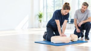 First aider practising chest compressions during QNUK First Aid at Work training